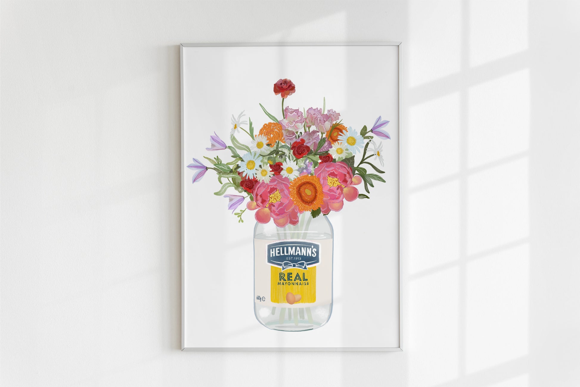 Framed artwork of flowers in a Hellmann's mayonnaise jar on a white wall.