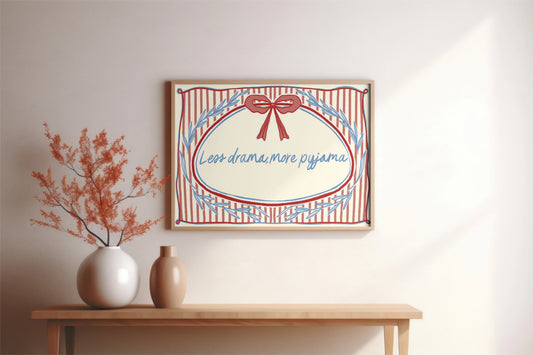 landscape orientation print with a beige background, pink stripes and a pink bow with red outline in the top middle. blue outlines of leave form an oval in the center and the quote reads in blue hand writing "less drama more pyjama"